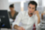 A man working in a call center cold calling potential clients.
